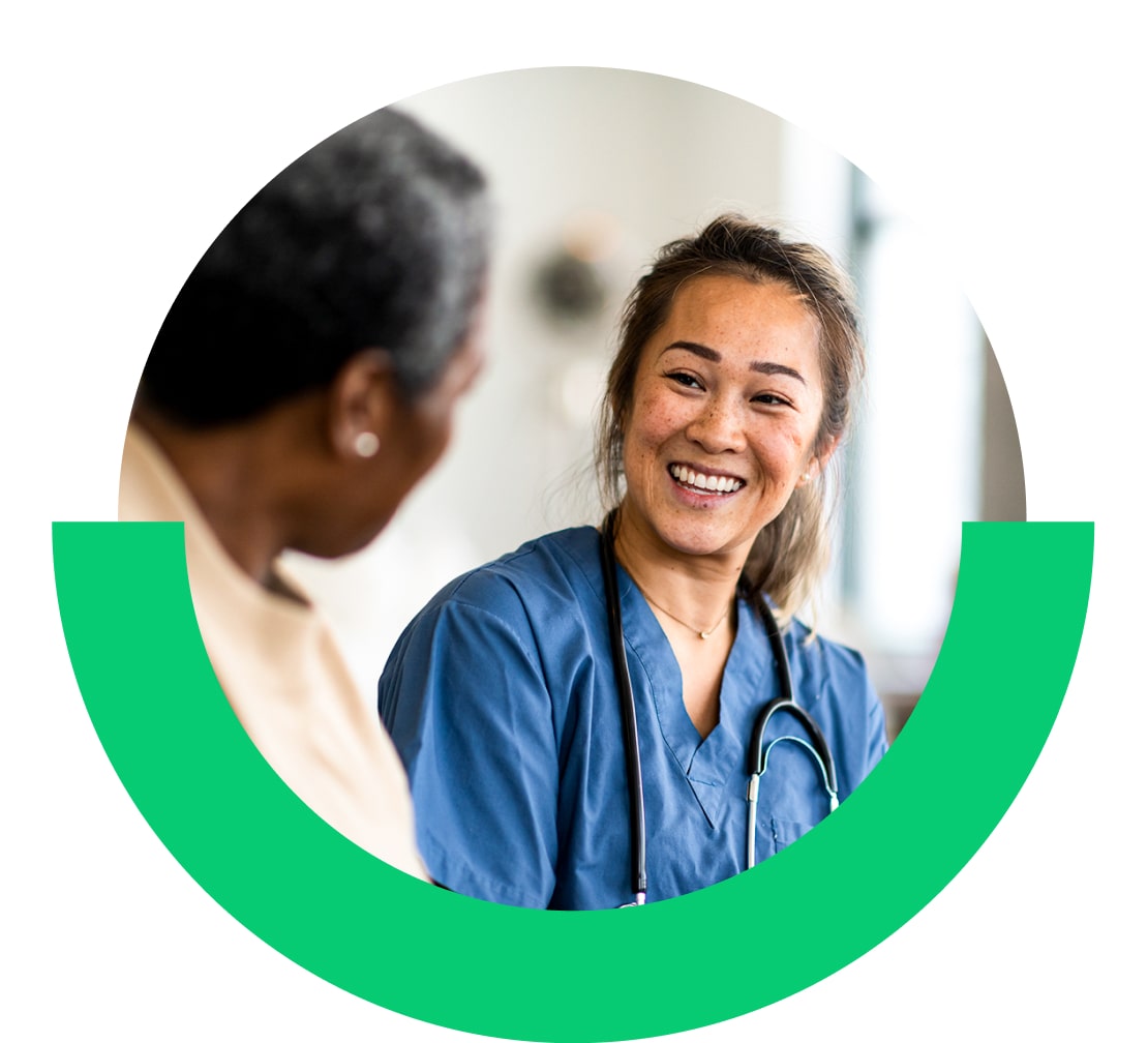 Nurse smiling while speaking with a patient.